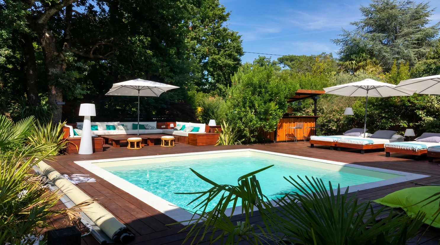 Piscine résidentielle avec eau turquoise claire, bordée de margelles en pierre naturelle et mur en briques